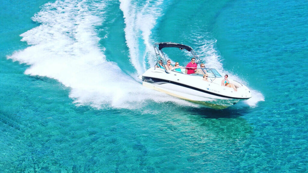 Speed boat with passengers creating white wake on turquoise waters of Lake Chelan
